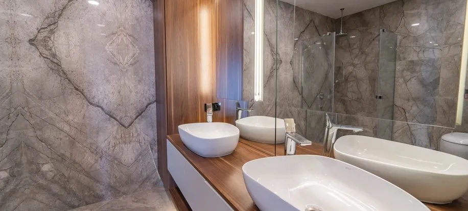 Banyo — doğal taş kaplama, ceviz tezgah ve çift lavabo